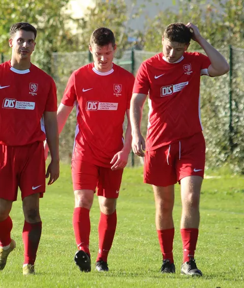Three St Brelade FC players walking off the pitch together